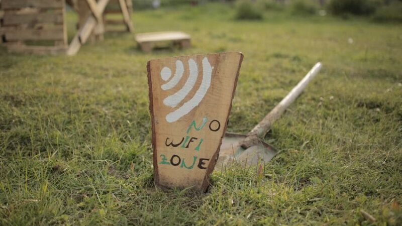 "No wifi zone" inscrit sur un panneau au milieu de la nature.