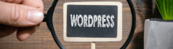 écriteau Wordpress sur une ardoise avec une main qui tient une loupe